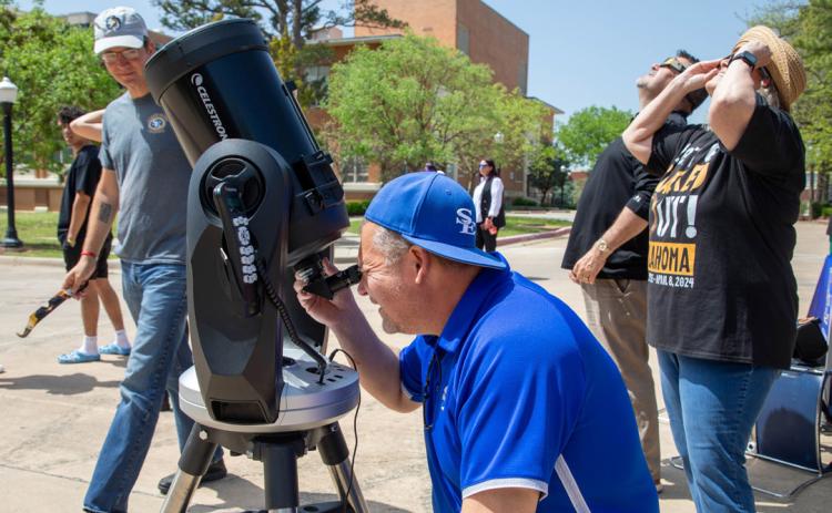 Southeastern Department of Chemistry, Computer, and Physical Sciences had an eclipse viewing event on Monday in front of the Student Union. There was a telescope with solar filter to allow viewers to see the surface of the sun in detail plus a second telescope that sent the image to a television screen in real time. Dr. Tim Smith, SE Department Chair/Professor of Chemistry, Computer &amp; Physical Sciences, looks through the telescope shortly after the eclipse began. Matt Swearengin | Durant Democrat