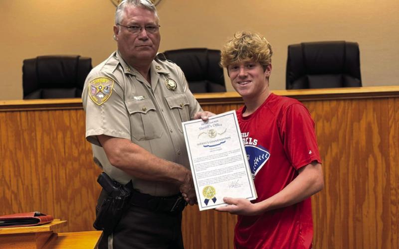 Bryan County Sheri_ Johnny Christian presents Colton Parker a Sheri_’s Commendation and Parker was also named an honorary sheri_’s deputy for his bravery when encountering a burglar. Photo provided